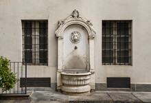 An Antique Stone Fountain Decorated With A Lion's Head In The Courtyard Of An Ancient Palace In The Historic Centre Of Turin, Piedmont, Italy