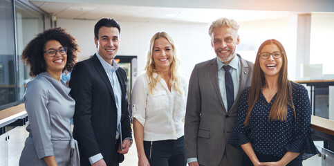 Diverse group of smiling colleagues standing together in an office