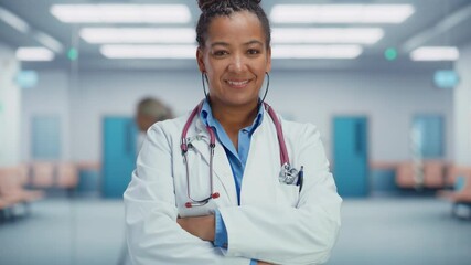 Wall Mural - Medical Hospital Medium Portrait: Confident African American Female Medical Doctor Crosses Hands, Looks at Camera and Smiles. Professional Black Physician in White Lab Coat Ready to Save Lives