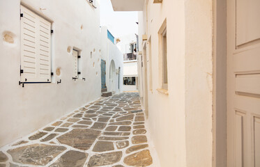 Wall Mural - Paros island, Greece. Whitewashed building, empty narrow cobblestone street at Naousa old town