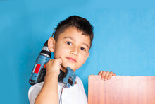 Boy Holds A Screwdriver On A Blue Background. A Student Studies The Work Of Tools