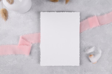 Canvas Print - blank wedding invitation stationery card mockup on grey stone table background with pink ribbon, feminine blog flat lay, top view. Minimalist mockup 5x7 ratio, similar to A6, A5