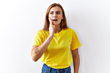 Poster - Young brunette woman standing over isolated background touching mouth with hand with painful expression because of toothache or dental illness on teeth. dentist