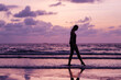 © Maria - Young slim woman silhouette walking on horizon background.