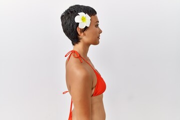 Poster - Young hispanic woman with short hair wearing bikini looking to side, relax profile pose with natural face and confident smile.