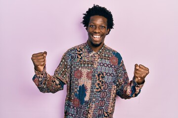 Poster - Young african american man wearing casual clothes screaming proud, celebrating victory and success very excited with raised arms