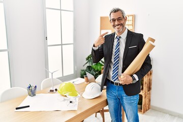 Poster - Middle age hispanic business man holding paper blueprints smiling cheerful showing and pointing with fingers teeth and mouth. dental health concept.