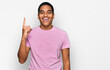 © Krakenimages.com - Young handsome hispanic man wearing casual pink t shirt pointing finger up with successful idea. exited and happy. number one.
