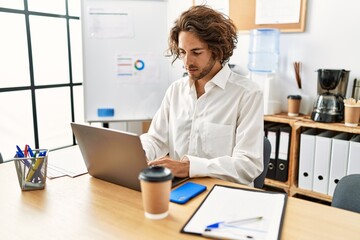 Wall Mural - Young hispanic businessman with relaxed expression working at office.