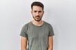 © Krakenimages.com - Young hispanic man with beard wearing casual t shirt over white background skeptic and nervous, frowning upset because of problem. negative person.