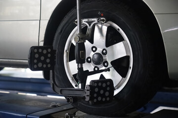 Mechanic installs sensor for wheel alignment job in repair shop.balancing wheel with aligner