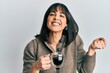 © Krakenimages.com - Young hispanic woman drinking a cup of coffee screaming proud, celebrating victory and success very excited with raised arm