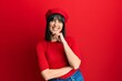 © Krakenimages.com - Young hispanic woman wearing french look with beret looking confident at the camera with smile with crossed arms and hand raised on chin. thinking positive.