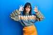 © Krakenimages.com - Young hispanic woman wearing casual winter sweater relax and smiling with eyes closed doing meditation gesture with fingers. yoga concept.