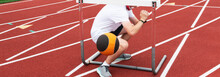 Boy Squatting Under A Hurdle After Dropping A Medicine Ball Over