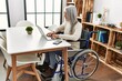 © Krakenimages.com - Middle age grey-haired woman uisng laptop sitting on wheelchair at home