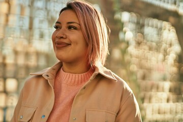 Young hispanic girl smiling happy standing at the city.