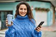 © Krakenimages.com - Young hispanic woman using smartphone drinking coffee at the city.