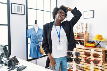 Sticker - African young woman working as manager at retail boutique smiling confident touching hair with hand up gesture, posing attractive and fashionable