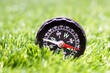 Tourist compass in the green grass, summer and travel