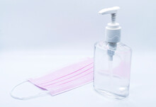 Sanitizer Jel Bottle With Pink Face Masks Isolated On White Background.