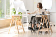 © Pixel-Shot - Young woman with physical disability working in office