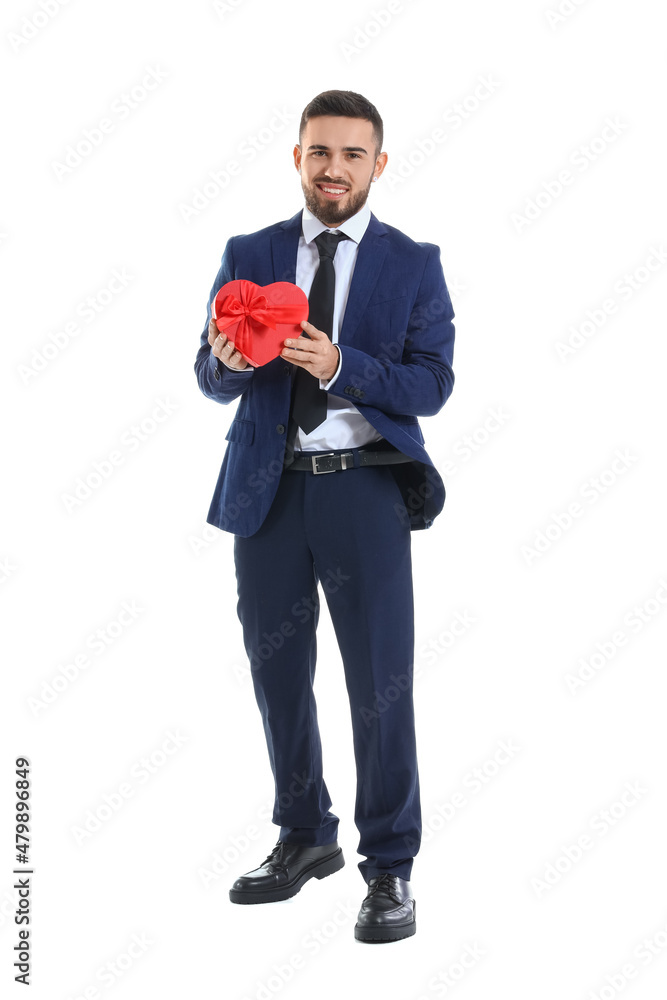 Handsome young man with gift for his girlfriend on white background. Valentine's Day celebration