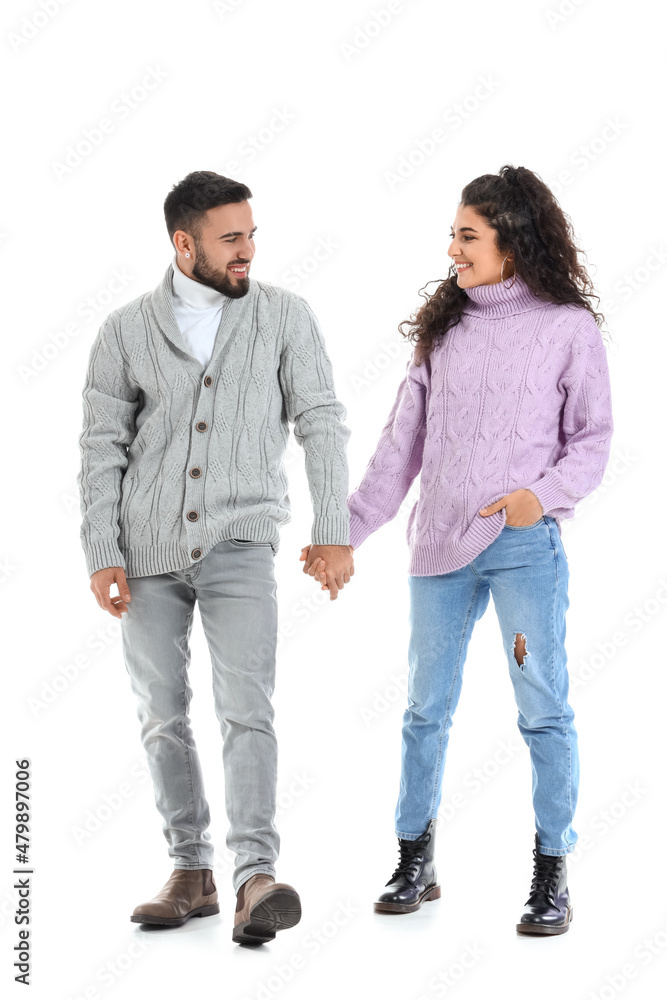 Happy young couple in warm sweaters on white background