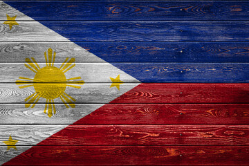 Wall Mural - The national flag of Philippines is painted on a camp of even boards nailed with a nail. The symbol of the country.