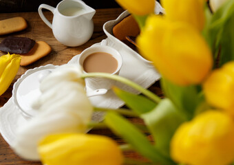 Wall Mural - Coffee tray near white and yellow tulips bouquet on wooden table