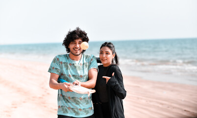 Wall Mural - young happy couple playing circket on beach indian pakistani model