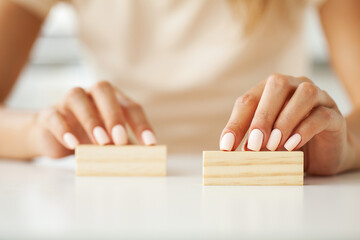 Women's hand holds two wooden blocks with a place for text