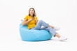 © F8  \ Suport Ukraine - Happy woman sitting on bean bag talking on smartphone laughing. Casual young woman with eyeglasses smiling speaking on the cellphone.