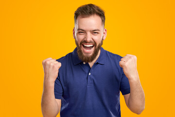 Positive man celebrating victory with clenched fists