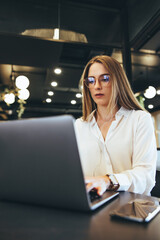 Young businesswoman working on a laptop in a modern workspace