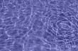 Ripple lilac water in swimming pool with sun reflection.