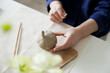 © Dina - woman sculpting a pumpkin out of clay with tools - hobby and DIY project at home hands close up