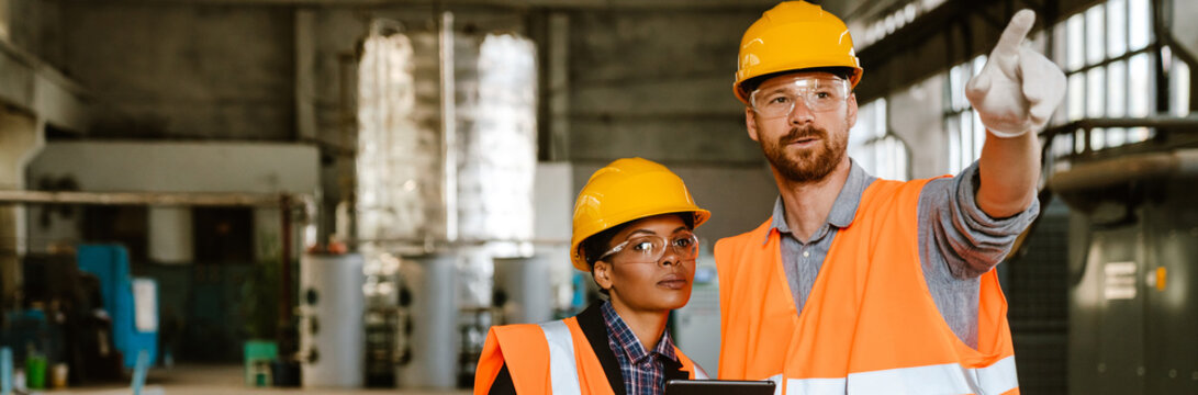 Multiracial man and woman working together at factory