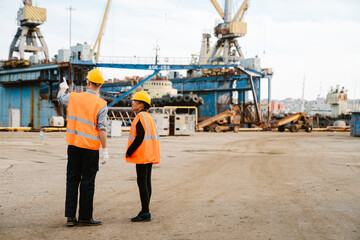 Multiracial man and woman talking while working at port