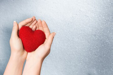 Poster - Person holding white heart in palm. Organ donation and insurance concept.