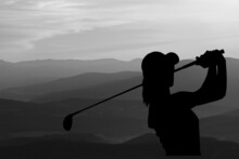 Silhouette Of A Golfer Swinging On Sky Background