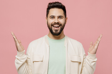 Poster - Young smiling surprised shocked happy caucasian man 20s wearing trendy jacket shirt spread hands look camera isolated on plain pastel light pink background studio portrait. People lifestyle concept.