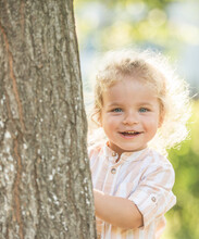 Cute Little Boy With Curly Blonde Hair Play Hide And Seek