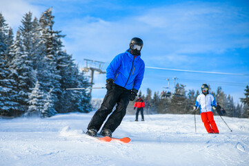 Skiers on a slopes in the mountains. Amazing weather conditions at Ski Mountain Resort.