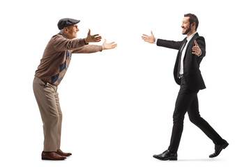 Wall Mural - Full length profile shot of an elderly man and a young businessman walking towards each other with open arms