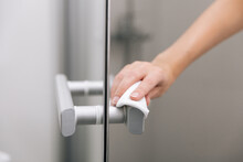 Cleaning Glass Door Handles With An Antiseptic Wet Wipe. Sanitize Surfaces Prevention In Hospital And Public Spaces Against Corona Virus. Woman Hand Using Towel For Cleaning Home Room Door Link.