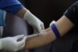 Close up Hand of nurse, doctor or Medical technologist in blue gloves taking blood sample from a patient in the hospital.