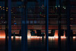 Blick durch Glasfassade in verlassene beleuchtete Lobby mit Bürostühlen