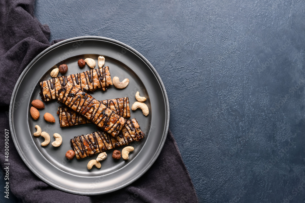 Tray with tasty chocolate nut bars on dark background