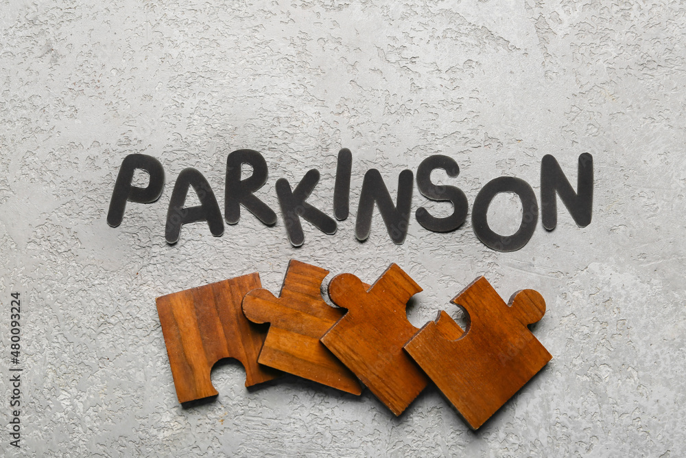 Word PARKINSON with puzzle pieces on grunge background